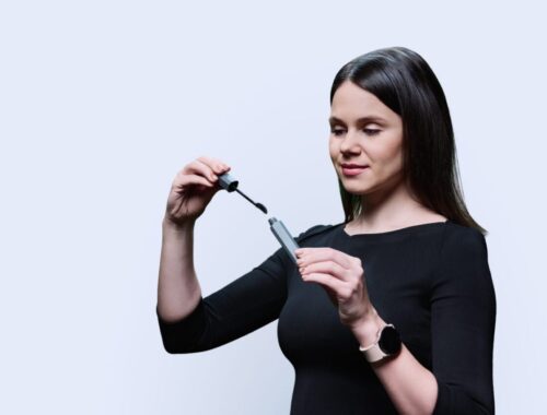 Une plume à cheveux colorée fixée dans une mèche de cheveux.