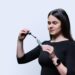 Une plume à cheveux colorée fixée dans une mèche de cheveux.